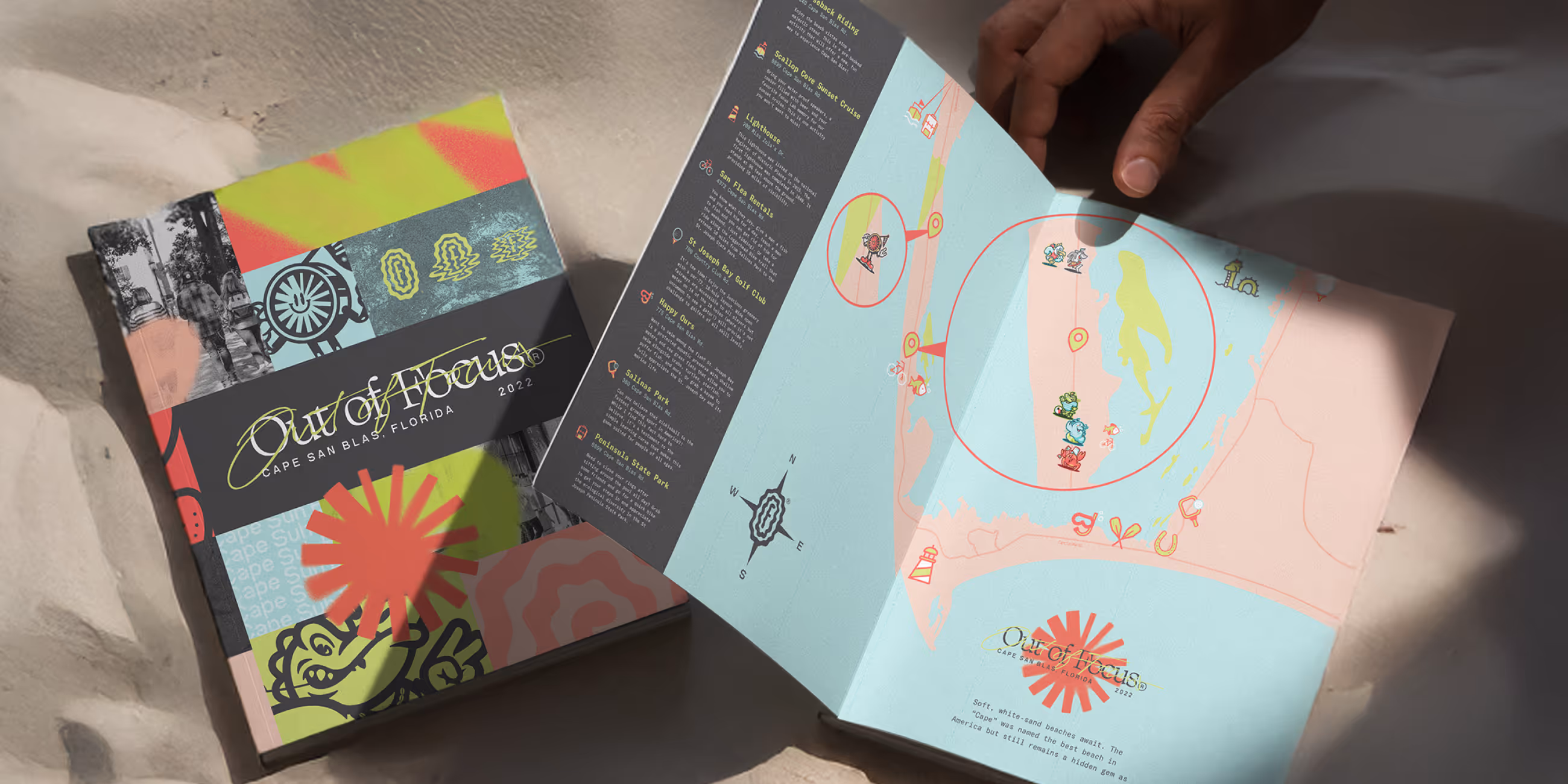 Hands holding an open colorful brochure titled 'Out of Focus' showing a stylized map and descriptions of locations in Cape San Blas, Florida.